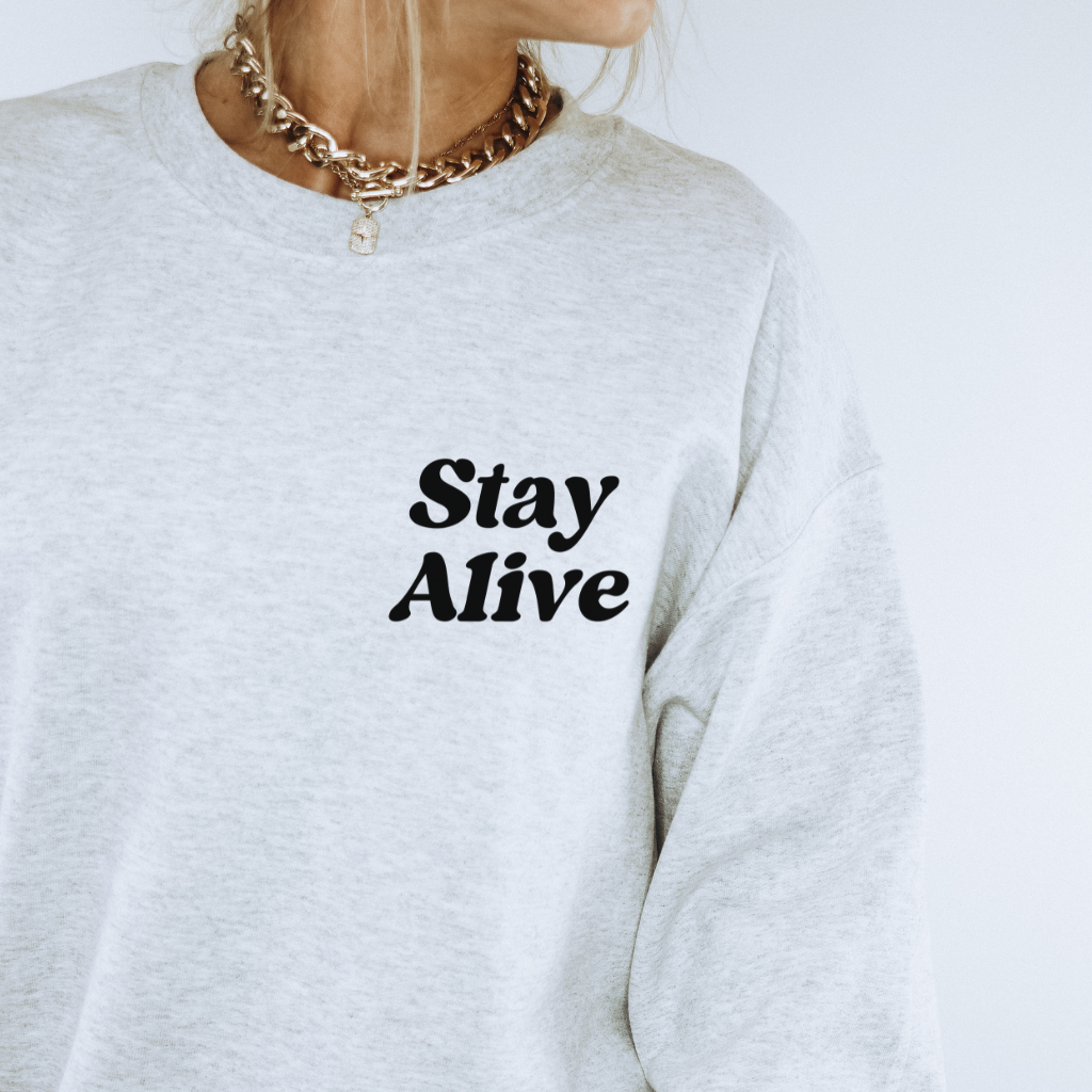 A cozy sweatshirt with Stay Alive on the front, and 99 reasons to stay alive on the back