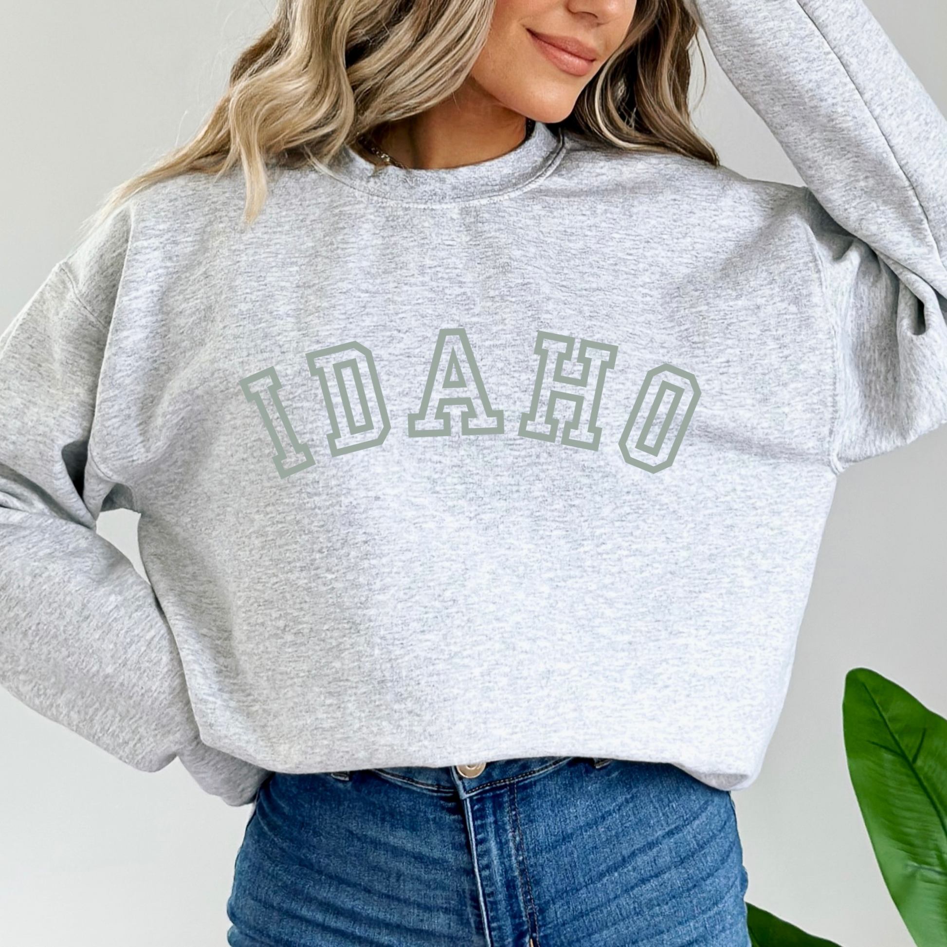 Idaho written across the chest of a light grey sweatshirt in a collegiate font.